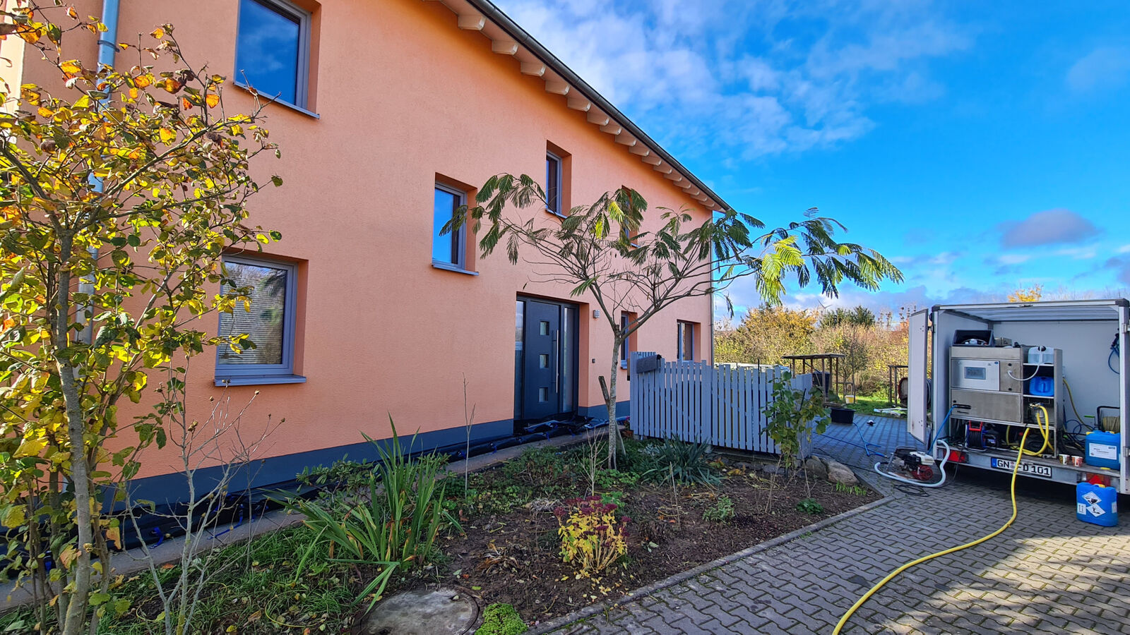 Fahrzeug der Fassaden-Dusche vor einem frisch gereinigten Wohnhaus