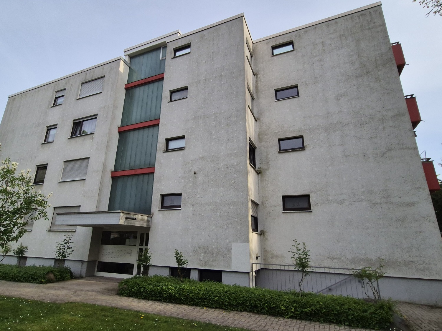 Vierstöckige Wohnanlage mit grau verschmutzter Fassade vor der Reinigung